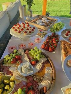 a table filled with lots of different types of food on plates and trays next to each other