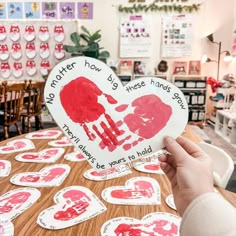 someone is holding up a heart shaped paper cutout with hand prints on it and the words no matter how hard those hands say