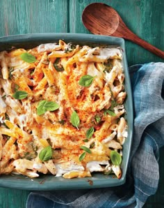 a casserole dish with chicken, cheese and spinach on a blue plate