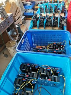 several blue bins filled with electronic equipment