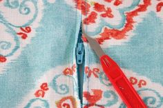 a pair of scissors is cutting through the fabric to sew on it's side