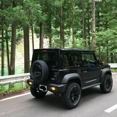 a black jeep is driving down the road