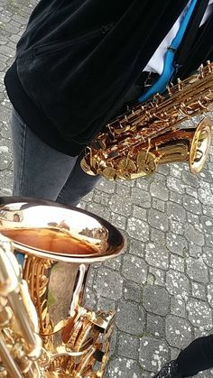 a person standing next to a gold saxophone