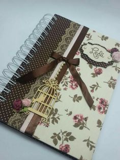 an open notebook with a birdcage and ribbon