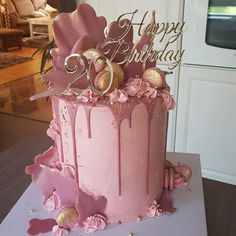 a pink birthday cake with gold decorations on it's top and the number twenty