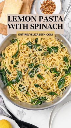 lemon pasta with spinach and parmesan cheese in a skillet on a marble table