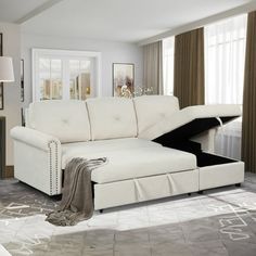 a living room with white furniture and curtains