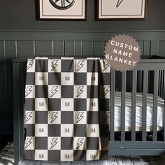 a baby crib with two pictures on the wall and a blanket in front of it