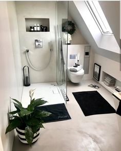 a bathroom with a toilet, shower and rugs on the floor in front of it