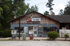 an old gas station with the sign the country store on it's front door