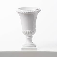 a white vase sitting on top of a table