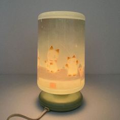 a lamp that is on top of a table next to a mouse and cat figurine