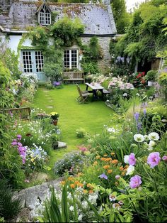 the garden is full of colorful flowers and greenery, including an old - fashioned house