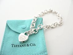 Overview: Offered for sale is a wonderful and gorgeous Return to Tiffany & Co. Sterling Silver Heart Padlock Charm Bracelet. Definitely a Tiffany piece that you will get your money's value for. It works perfectly with pretty much any attire your put on, AND is a great statement piece. The piece looks fabulous worn alone, but is also a wonderful piece with which to start or add to your Tiffany collection. The Heart Padlock charm opens and closes so you can take it off the bracelet and wear it Luxury Lock Jewelry For Gift, Return To Tiffany, Heart Padlocks, Gift Pouch, Bracelet Charm, Tiffany Heart, Sterling Silver Heart, Heart Charm Bracelet, Love Gifts