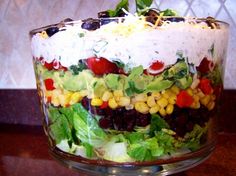 a salad in a glass bowl with dressing on top