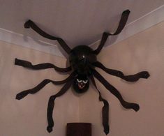 a large spider mounted on the wall above a toilet