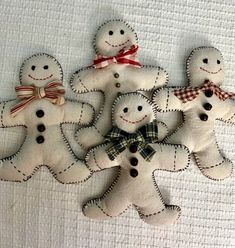 five handmade gingerbread men with bow ties on white linens, one in the shape of a snowman