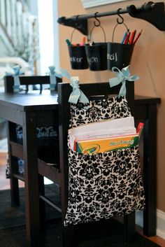 a black and white bag is hanging on the wall next to a table with books