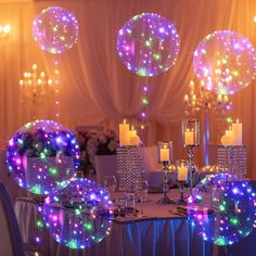 the table is set with candles, plates and large balloons in the shape of stars