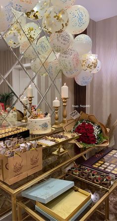 a table with many balloons and cakes on it