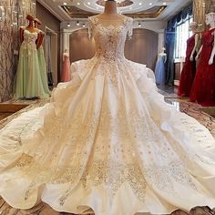 a wedding dress is on display in a store with mannequins behind it