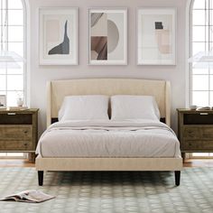 a white bed sitting in a bedroom next to two framed pictures on the wall above it