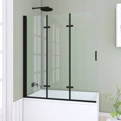 a bathroom with a tub, shower head and window in the corner on the wall