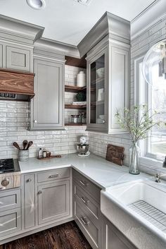 a kitchen with gray cabinets and white counter tops