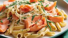 a white plate topped with pasta and salmon