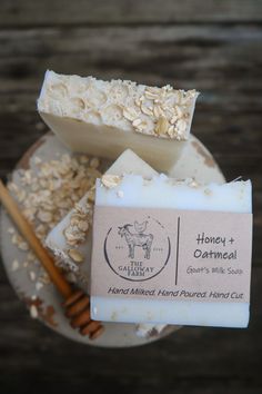 a bar of soap sitting on top of a white plate next to two cinnamon sticks