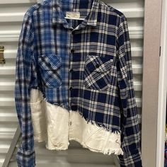 a blue and white plaid shirt hanging on a rack