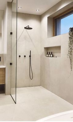 a bathroom with a shower, sink and mirror in it's center wall is shown