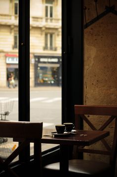 two chairs sitting next to each other in front of a window with a view of the street