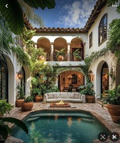 an outdoor living area with a pool and patio furniture in front of the house, surrounded by greenery