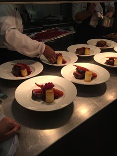 several plates with food on them sitting on a counter in a restaurant or other place