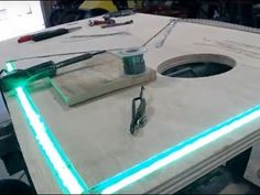 a table that has some tools on it and is lit up with green light coming from the hole