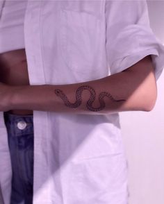 a person with a snake tattoo on their arm