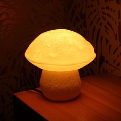 a mushroom shaped light sitting on top of a wooden table