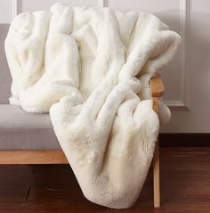 a white blanket sitting on top of a wooden bench