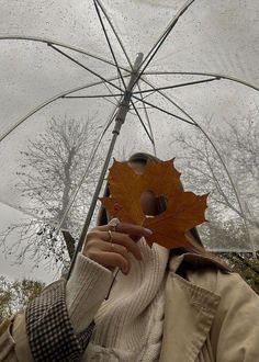 a woman holding an umbrella with a leaf on it