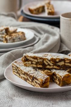 several pieces of dessert on a plate with coffee in the back ground and plates full of pastries