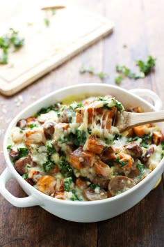 a casserole dish with sausage, broccoli and cheese in it on a wooden table