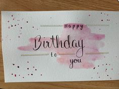 a card with the words happy birthday to you written on it and pink watercolor spots