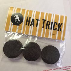 three oreo cookies sitting on top of a plastic bag next to a sticker that says hat trick