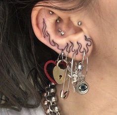 a close up of a person's ear with many charms attached to the ear