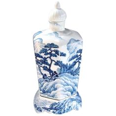 a blue and white vase with a tree on it's side, sitting in front of a white background