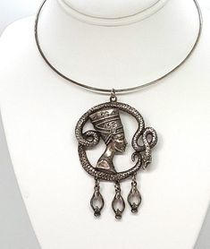 "With the discovery of Queen Nefertiti's bust and later King Tuts tomb in the 20s Egyptian Revival became a craze. Queen Nefertiti was a symbol of beauty and feminine power.  This vintage 20s silver pendant has been beautifully cast, it is heavy and has fine detail. It measures 3.25\" high not measuring the jump ring. The penny is shown for sizing. It is a very good quality piece. THE COLLAR NECKLACE IS NOT INCLUDED. It is made of a silver colored metal. In very good condition, no wear noted Bec Antique Ankh Collectible Jewelry, Nefertiti Bust, Gold Claddagh Ring, Queen Nefertiti, Art Deco 1920s, Snake Pendant, Claddagh Rings, Feminine Power, Silver Art