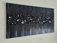 a painting hanging on the wall with rocks and gravel in it's bottom layer