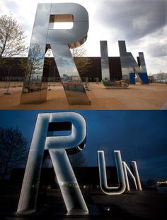 the letters r and u are made out of metal, which is in front of a building