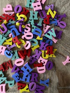 colorful wooden alphabets are scattered on the floor for use as wall hangings or decorations